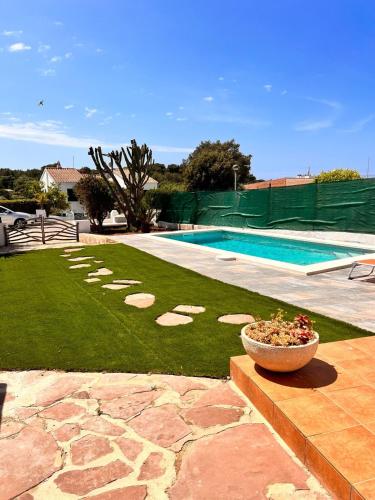 a backyard with a swimming pool and a bowl of flowers at Casa a pocos minutos de la playa de Cala Galdana in Cala Galdana