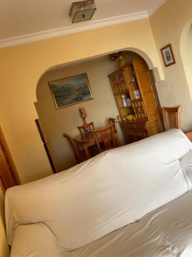 Schlafzimmer mit einem Bett, einem Tisch und Stühlen in der Unterkunft One bedroom, top floor, by the sea, Fuengirola in Fuengirola
