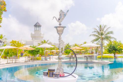 a fountain in front of a pool at a resort at SAii Lagoon Maldives, Curio Collection By Hilton in South Male Atoll