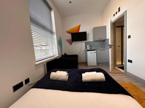 a bedroom with a large bed and a kitchen at Serviced Ensuite Double Room - Near Greenwich Park - The O2 Arena - Nearby Transport Links to Central London - New Cross Station - Lewisham SE14 in London