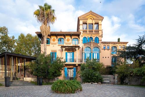 a large building with a palm tree in front of it at Hotel Boutique Mas Passamaner in La Selva del Camp