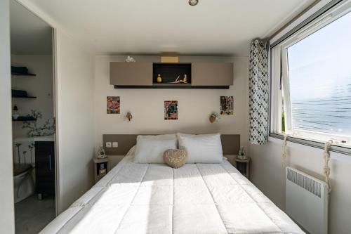 1 dormitorio con 1 cama y ventana grande en Mobil-home, en Les Mathes