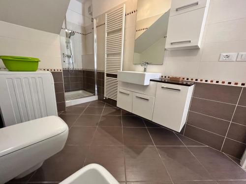 Villa Franca في غرادو: حمام مع حوض أبيض ومرحاض