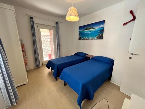 dwa łóżka w pokoju z niebieską pościelą w obiekcie Villa Franca w Grado