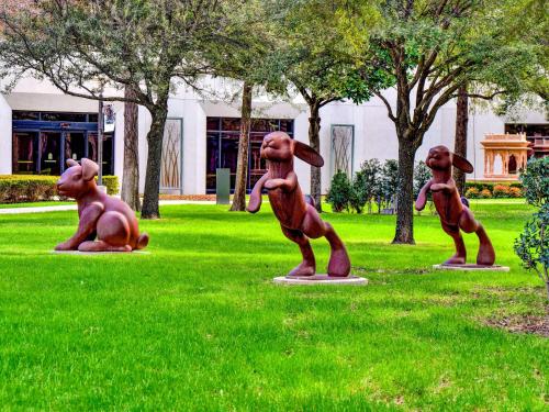 a statue of three dogs sitting in the grass at Hilton Anatole in Dallas