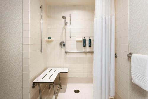 a white shower with a bench in a bathroom at DoubleTree by Hilton San Jose in San Jose