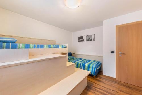 a bedroom with a bed and a closet and a door at Apartment Litegosa - Casa Alma in Tesero