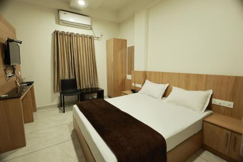 ein Schlafzimmer mit großem Bett und Fernseher in der Unterkunft Slice of Heaven in Mundakāyam