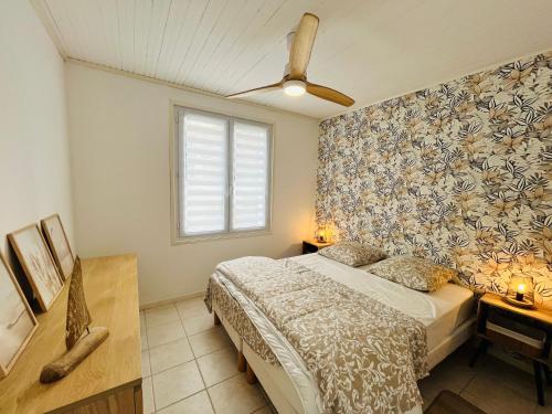 une chambre avec un lit et un ventilateur de plafond dans l'établissement Maison du centre, charme & océan, à Saint-Jean-de-Monts