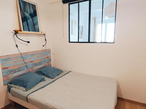 une chambre avec un lit et une fenêtre dans l'établissement Deux pièces rénové climatisé cœur du vieil Antibes, à Antibes