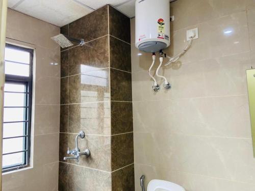 a bathroom with a shower with a toilet and a sink at Abuzz Oxfordcaps Cedar Homes in Jhājra