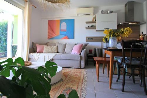 ein Wohnzimmer mit einem Sofa und einem Tisch in der Unterkunft Cosy appartement entre vignes et garrigue avec piscine in Péret