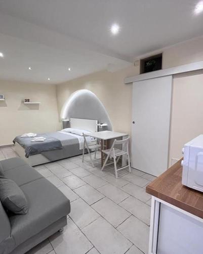 ein Schlafzimmer mit einem Bett und einem Tisch in einem Zimmer in der Unterkunft Al rifugio di rosmy in Bari