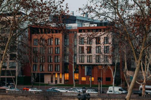 a building with cars parked in front of it at Hotel Monday by DNT Group in Tbilisi City
