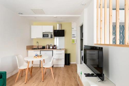 uma cozinha com mesa e cadeiras num quarto em L'Ecrin Vert - 150m Restaurant 3 étoiles em Vonnas