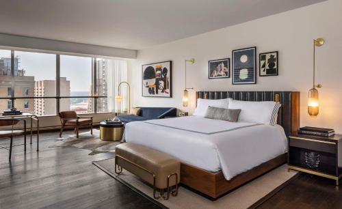 a bedroom with a large bed and a living room at Thompson Dallas, by Hyatt in Dallas