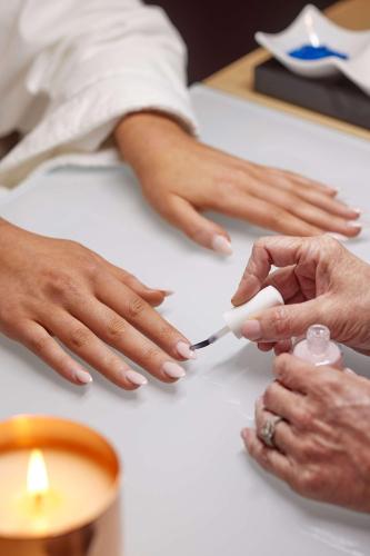 a woman getting her nails done at a table at Thompson Dallas, by Hyatt in Dallas