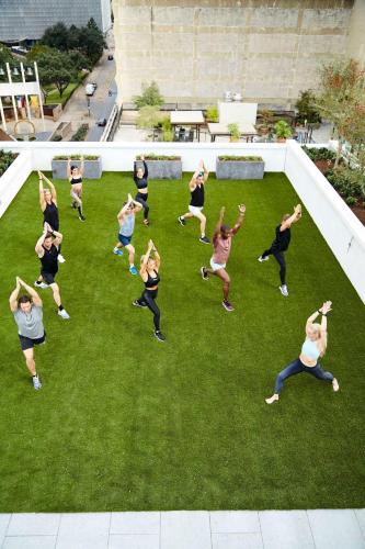 a group of people doing yoga on the grass at Thompson Dallas, by Hyatt in Dallas