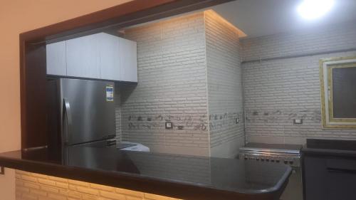a kitchen with a refrigerator and a brick wall at Bright CityStars in Cairo