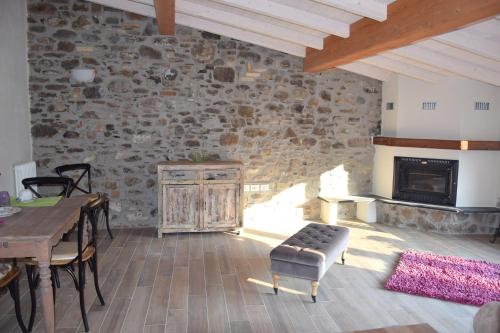 - un salon avec une table et une cheminée dans l'établissement Corte Doria Dolceacqua Agriturismo, à Dolceacqua