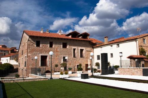 a large brick building with a green lawn in front at Hotel PALACIO IVAN TARIN in Monteagudo del Castillo