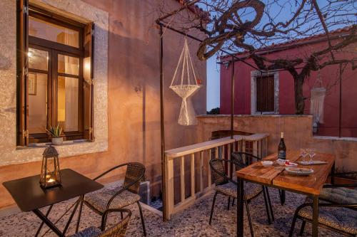 a patio with a table and chairs on a balcony at CARPE DIEM HOTEL in Archanes