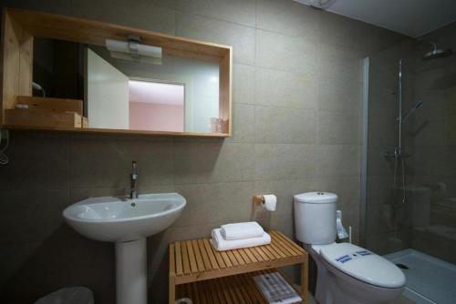 a bathroom with a sink and a toilet and a mirror at Hotel PALACIO IVAN TARIN in Monteagudo del Castillo