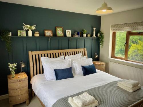 雅芳河畔布拉福的住宿－Cosy 3-bedroom home with garden and log burner.，一间卧室配有一张带蓝色墙壁的大床