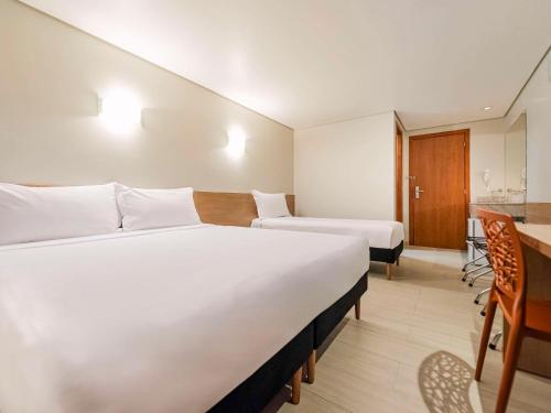 a hotel room with two beds and a kitchen at ibis Styles Goiânia Shopping Estação in Goiânia