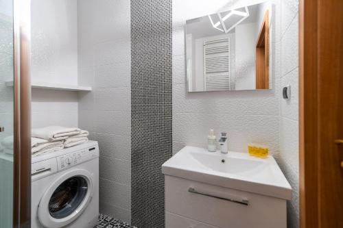 een badkamer met een wasmachine en een wastafel bij APT Nadmorskie - Portowe in Kołobrzeg