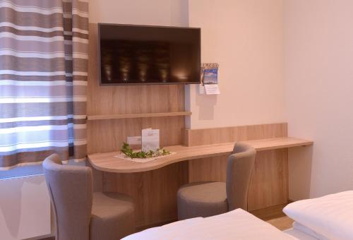 a hospital room with a desk and a tv at Gasthof Ziegler Hotel & Restaurant in Lindau