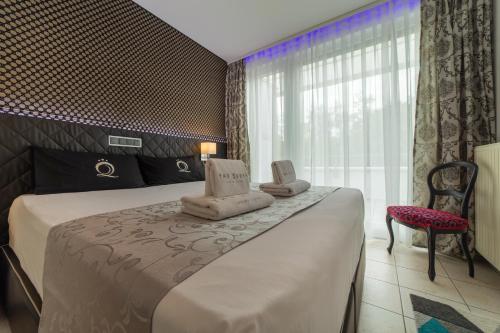 une chambre d'hôtel avec un lit et des serviettes. dans l'établissement VILLA ADRIANA-The Queen Apartments Luxury Living, à Luxembourg