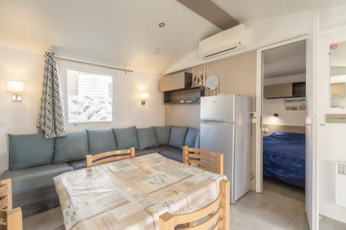 - un salon avec un canapé, une table et un réfrigérateur dans l'établissement Siblu Bonne Anse Mobilhome 510, aux Mathes