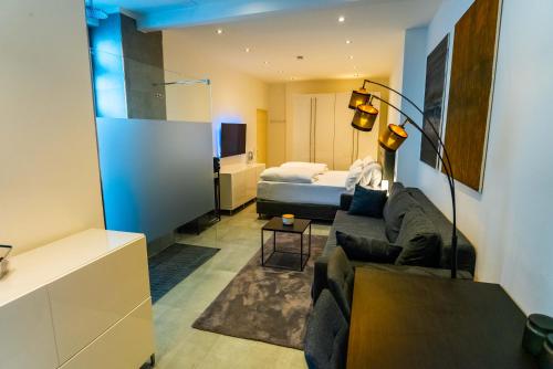 ein Wohnzimmer mit einem Sofa und einem Bett in der Unterkunft White Lofty und White Studio in Düsseldorf