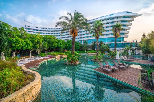 ein Resort mit einem Swimmingpool und einem Gebäude in der Unterkunft Concorde De Luxe Resort Lara Antalya- Prive Ultra All Inclusive in Lara