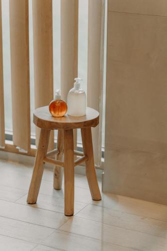 a small wooden table with a bottle and a donut on it at Les Arbres sous le vent à 10 min de Pairi Daiza in Jurbise