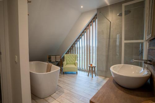 a bathroom with two tubs and a glass shower at Les Arbres sous le vent à 10 min de Pairi Daiza in Jurbise