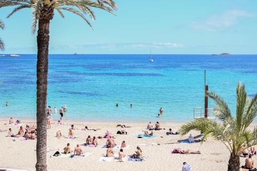 a group of people on a beach with the ocean at Hotel Figueretes in Ibiza Town