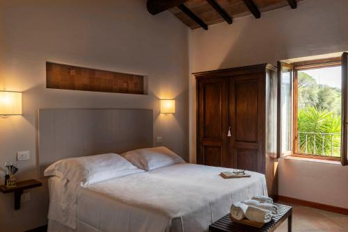 a bedroom with a white bed and a window at Tenuta Il Cicalino in Massa Marittima