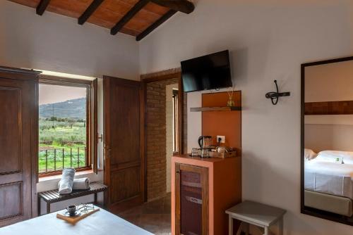 a room with a bedroom with a bed and a window at Tenuta Il Cicalino in Massa Marittima