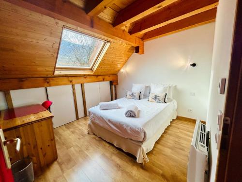 een slaapkamer met een bed in een kamer met een raam bij Chez Fred - CLG Savoie - 2Ch - 1 SDB in Chevillard