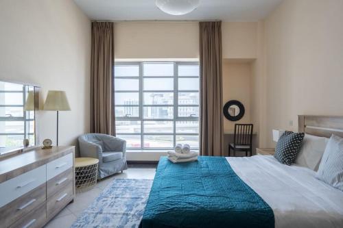 1 dormitorio con cama, escritorio y ventana en HiGuests - Incredible City Views in Deira 5-min to Airport, en Dubái