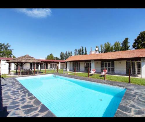 盧漢德庫約的住宿－POSADA DE LA LUNA，一座大蓝色游泳池,位于房子前