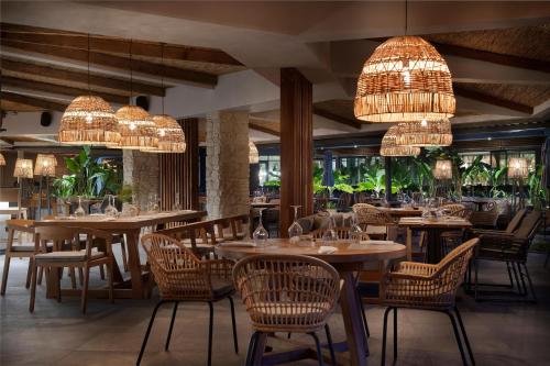 a restaurant with wooden tables and chairs and chandeliers at Miramare Beach Hotel - Ultra All Inclusive in Side