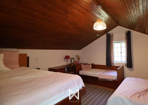 a bedroom with two beds and a window at MyStay - Casa da Carvalha in Arcos de Valdevez