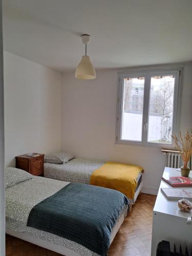 um quarto com 2 camas e uma janela em Appartement de designer, Cosy Lumineux, 3 chambres em Le Kremlin-Bicêtre