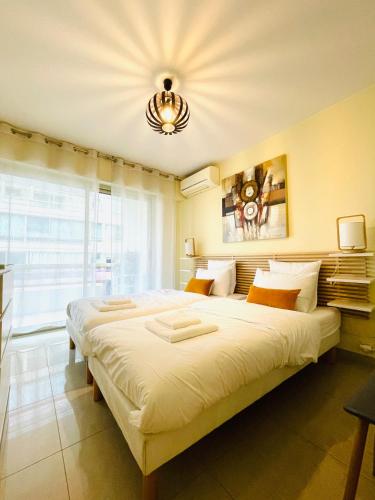 un grand lit dans une chambre avec une grande fenêtre dans l'établissement Bel appartement Centre ville, mer, Croisette, à Cannes