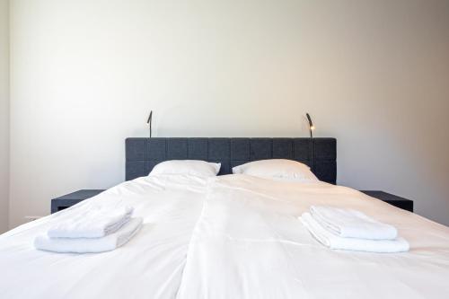 a white bed with two white towels on it at Familievilla Nieuw Zeeland in Oosterend