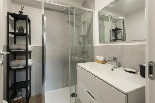 a bathroom with a sink and a glass shower at Moderno e Confortevole Loft tra Navigli e Bocconi in Milan