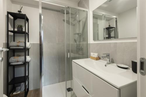 a bathroom with a sink and a glass shower at AMBROSIA HOME, moderno Loft tra Navigli e Bocconi - Daniele Case Vacanza in Milan